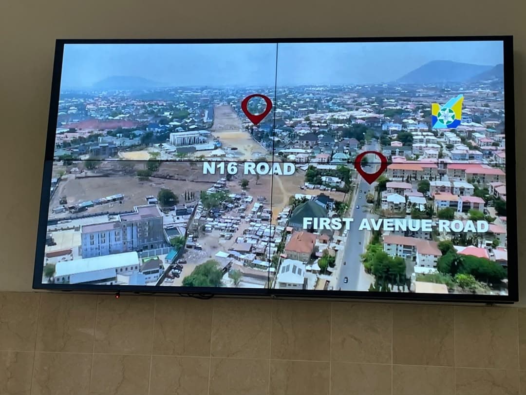 Wall-mounted two-by-two video wall displaying an aerial map with labelled roads